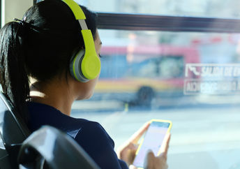 Woman listening to podcast on bus