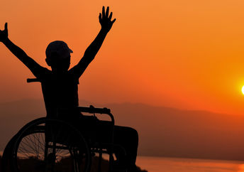 Wheelchair user enjoying a sunset by the sea