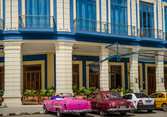 Classic cars are among the taxis waiting for passengers outside of Cuba’s Hotel Telégrafo