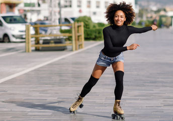 Young woman on roller skates riding outdoors in urban street