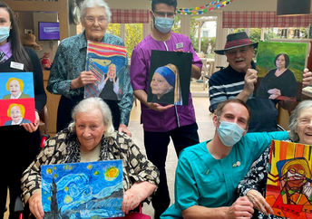 Residents at the Sandfields residential home for seniors pose with some of their art