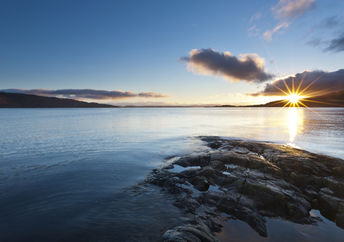 Beautiful sunset over a rocky lake in Scotland promotes spirituality.