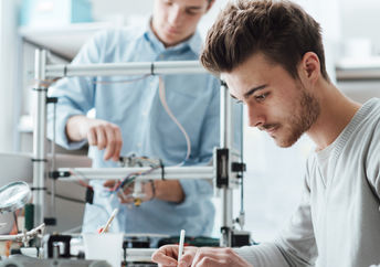 Students in a lab using a 3D printer