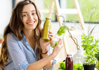 A woman doing a detox shows her healthy smoothies along with detoxifying fruits and vegetables.