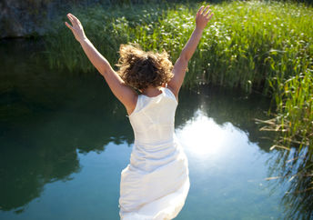 Young woman jumping into an idyllic lake.