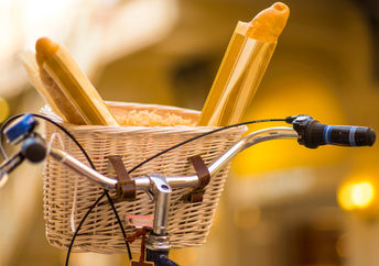 A basket with fresh goods on a bicycle.