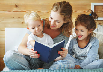 Mother reading a book to her children.