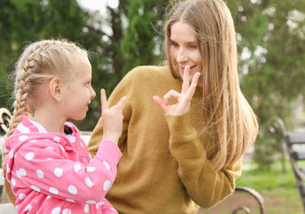 A woman and her daughter sign together using ASL.