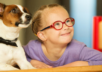 Cute girl learning with the help of a friendly dog.
