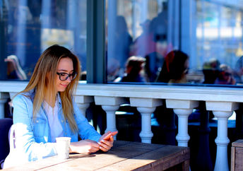 Young woman using her smartphone to boost productivity.