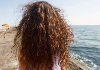Young woman with long hair at the beach.