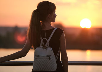 A young woman standing by the lake.