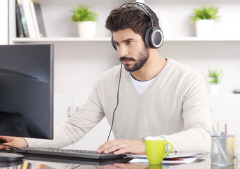 A young man sitting with headphones.