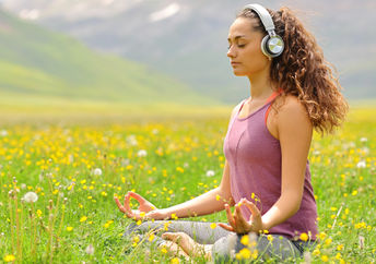 woman listening to guided meditation in nature