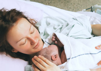 Mother cuddling her newborn baby.