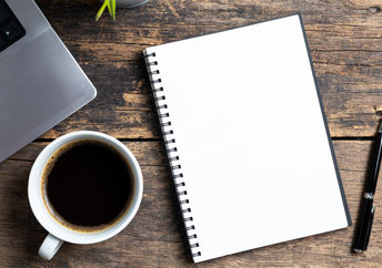 An empty notebook and a computer.