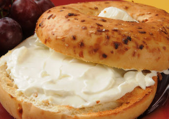 An onion bagel with a smear of plant-based vegan cream cheese.