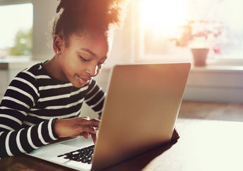 A young girl using a laptop.