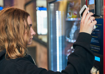 Women using a conventional vending machine at work