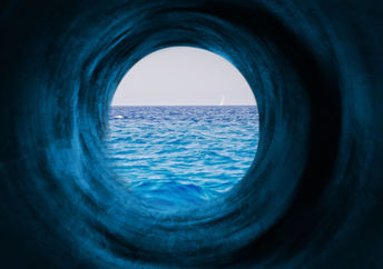 Blue tunnel to a calm sea symbolizing the way to tranquility and goals.