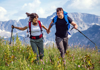 Hikers in a mountain meadow are exploring the world in a sustainable way.