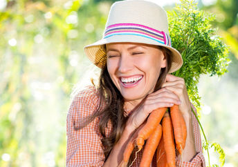 Woman with some just-picked organic carrots.