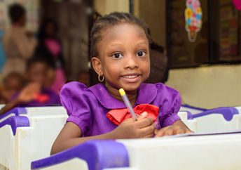 Smiling African child in her classroom.