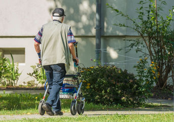 Senior man walking in his yard.