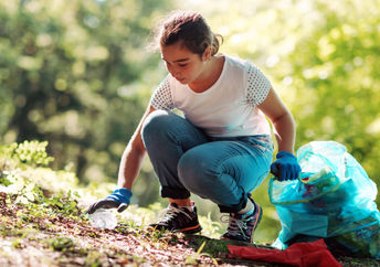 Teenage girl cleaning a community park.