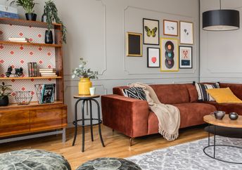 Eclectic living room with a rust-colored sofa.