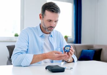 A man checking his blood glucose level.
