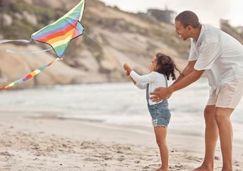 A father and daughter flying a kite.