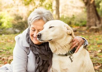 A senior woman cuddling with her dog.
