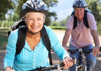 Two healthy seniors riding bikes.