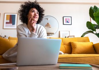A woman thinking in a living room.