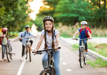 A group of children ride their bicycles.
