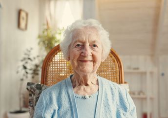 An elderly woman smiles.