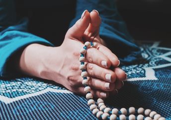 Woman meditating with a mala.