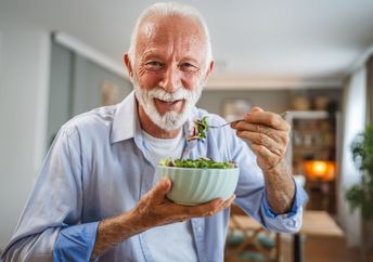 A man eats a salad.