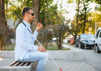 A partially-sighted man navigates public transport with the aid of technology.