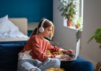 A teen focused on an online lesson.