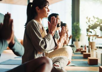 People relaxing in a yoga class.