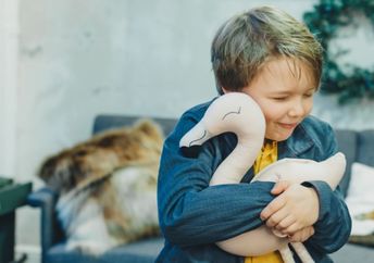 A boy hugs a plush toy.