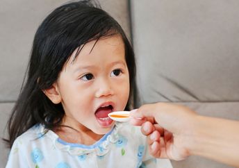 Girl taking her medicine.