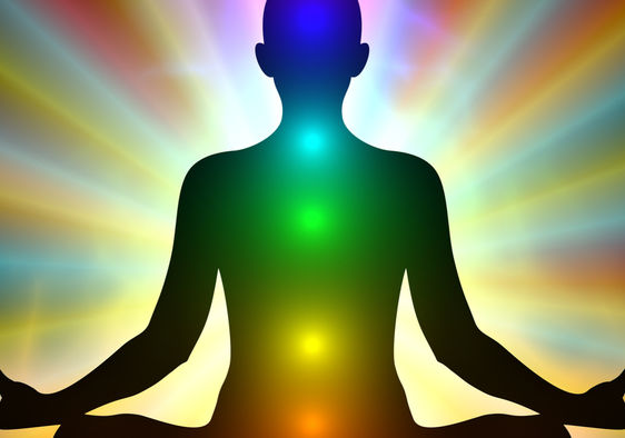 Aura colors and glowing chakras on a man who is meditating.