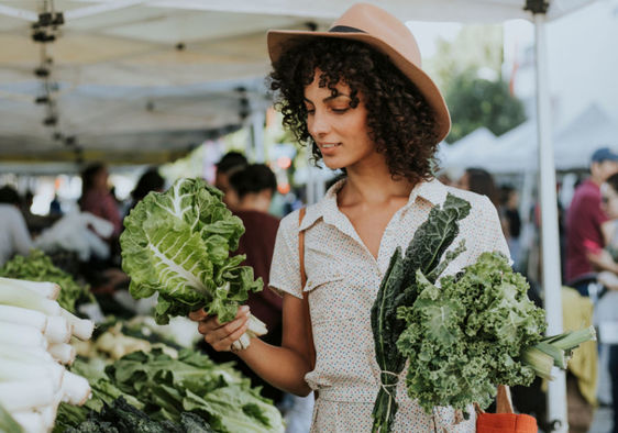 Woman buying kale at a farmers’ market