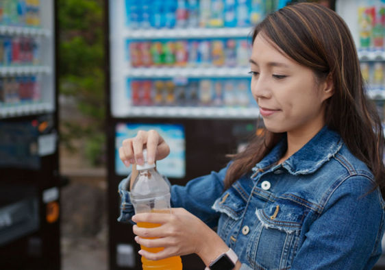 Woman purchasing a beverage from a vending machine.