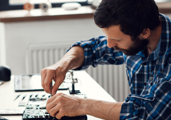 A man repairing a laptop computer.