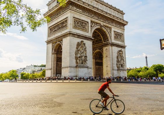Man cycling near the Paris landmark Arc de Triomphe.