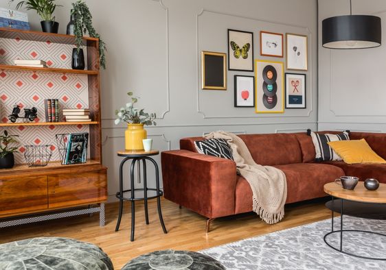 Eclectic living room with a rust-colored sofa.